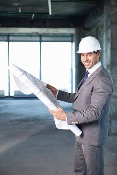 Surveyor Presenting Site Plans During Medical Project Review - ALTA SURVEY Ohio Land surveyor in hard hat holding site plans during a facility construction review