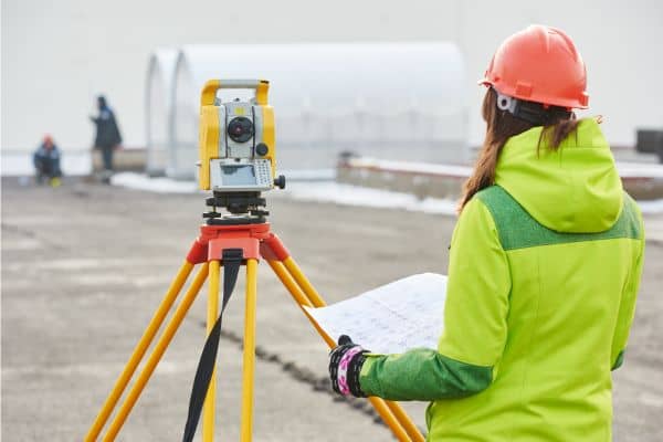 Licensed surveyor performing ALTA survey on commercial site to prevent boundary and easement issues.