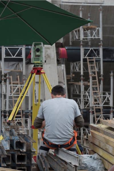 Land surveyor using total station at construction site to meet rising demand for ALTA land title surveys during infrastructure development

