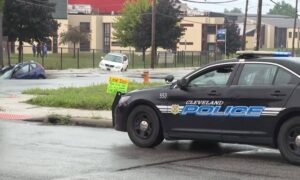 Flooded street in Cleveland with police response, highlighting the need for a Flood Elevation Certificate after heavy rain.