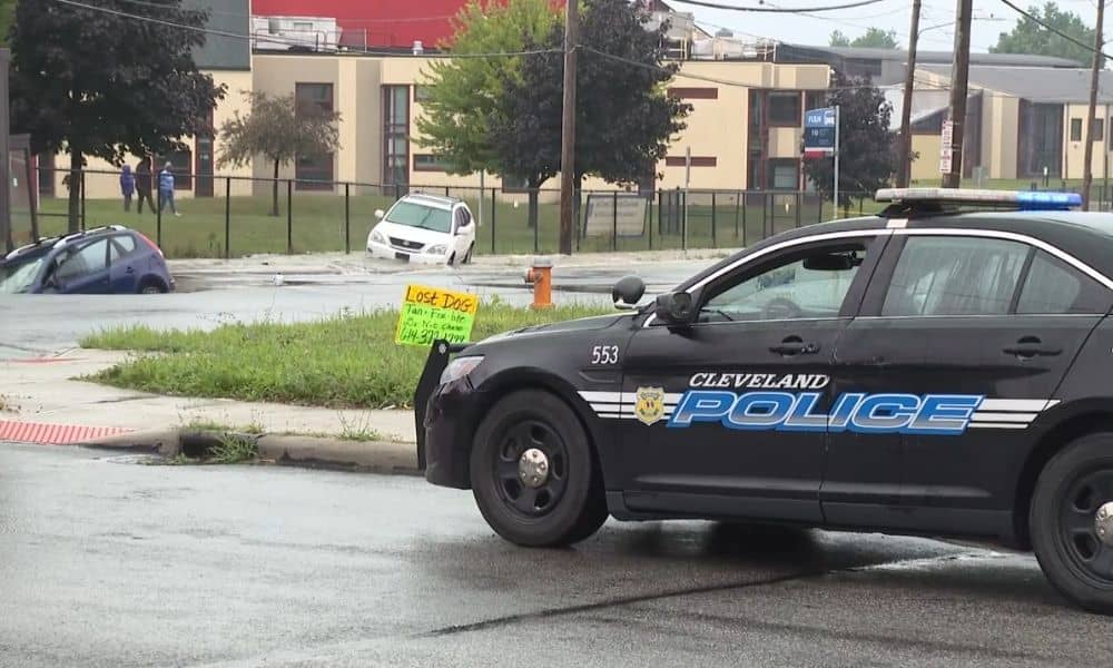 Flooded street in Cleveland with police response, highlighting the need for a Flood Elevation Certificate after heavy rain.

