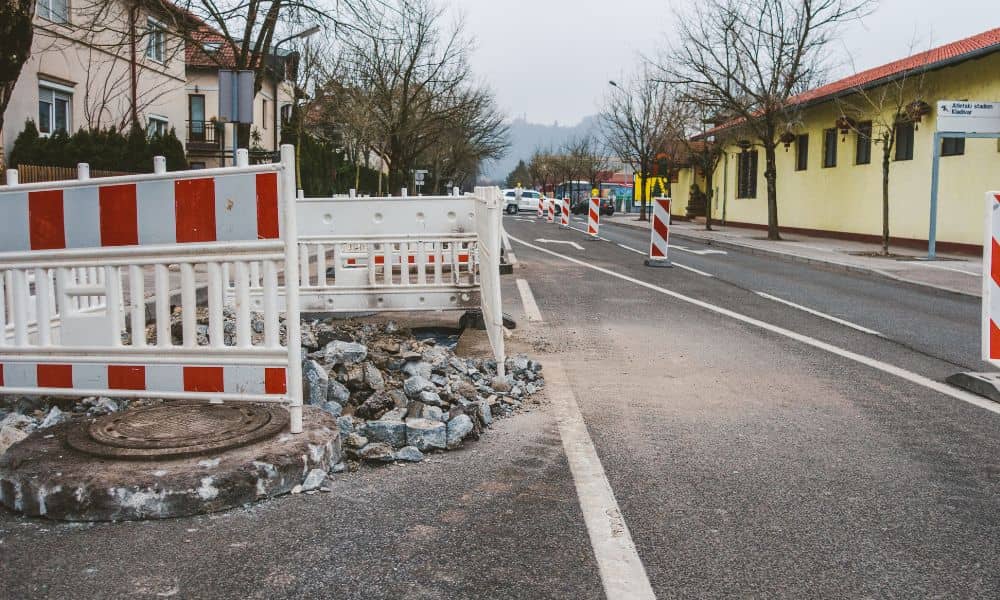 Utility repair work and road barriers near neighborhood properties illustrating why an updated ALTA Title Survey is important