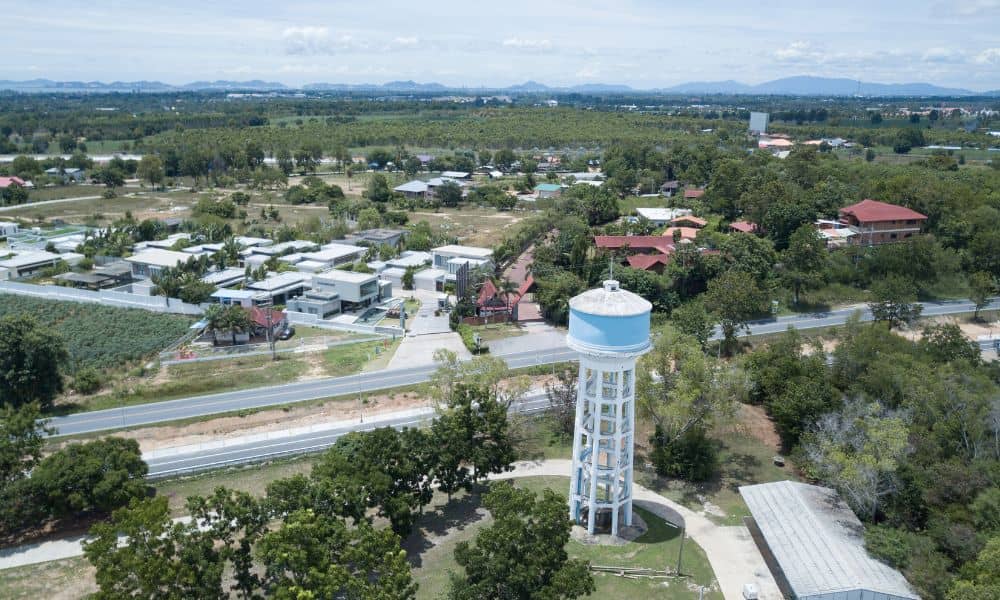 Drone land surveying capturing an aerial view of a historic water tower and surrounding landscape for restoration and mapping work
