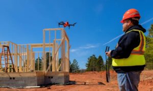 A land surveyor performing drone surveying at a construction site to capture aerial data for mapping and project planning