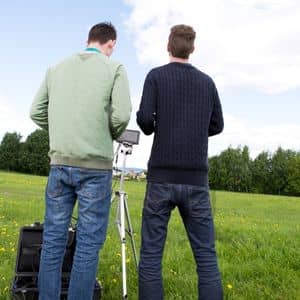 A licensed survey team preparing a drone for flight during drone land surveying work