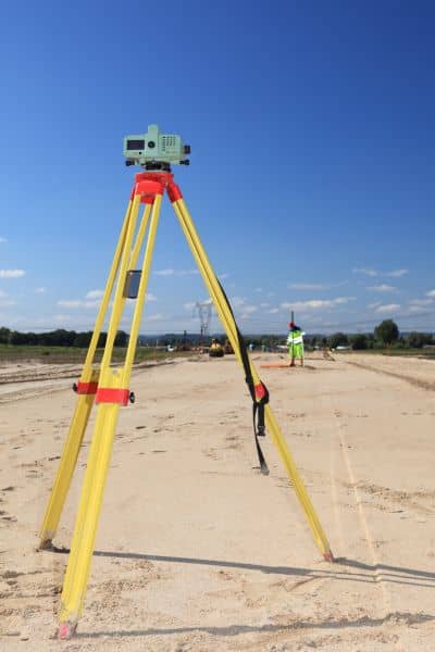 Surveyor using a total station to mark layout points during construction staking on a development site