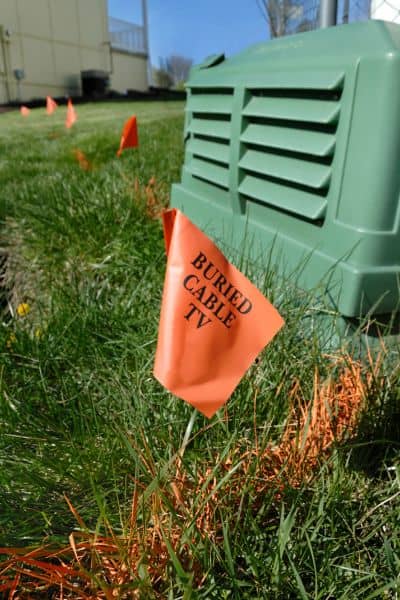 Orange flags marking property boundaries during a property line survey in a yard