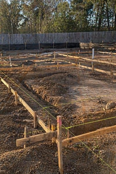 Wood stakes and string lines marking the layout of a house before construction begins